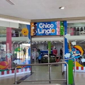 Fachada de la tienda para niños Chico Lindo. En su vitrina muestra ropa y accesorios con imágenes alegres y coloridas